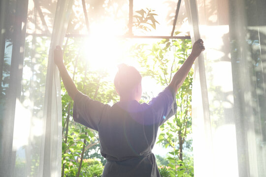 Person stretching by a sunlit window during a morning routine